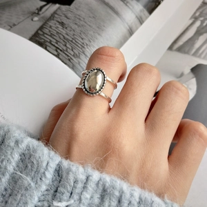 Detailed view of vintage silver oval ring featuring twisted texture worn with blue sweater