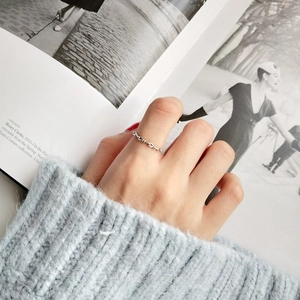 Detailed view of 925 sterling silver knotted ring with textured weave pattern on hand