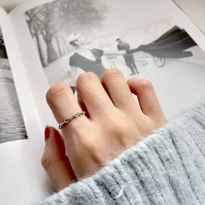 Detail shot of a minimalist S925 sterling silver twisted rope ring worn by a model