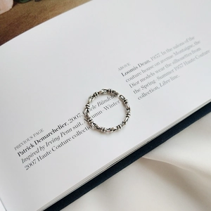 Macro detail of retro 925 sterling silver knotted chain ring on a stylish magazine