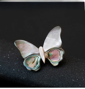 Macro shot of butterfly brooch with white mother of pearl and abalone shell inlay