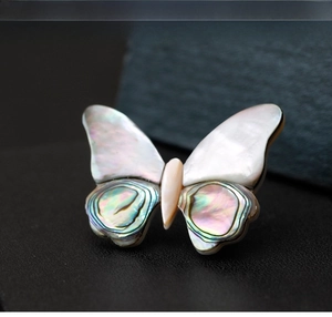 Macro view of butterfly brooch with iridescent abalone shell and mother of pearl inlays