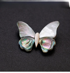 Detailed close-up of a butterfly brooch crafted with natural shell and abalone inlay