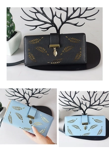Detail of minimalist leather long wallet with gold leaf hollow design and pendant charm