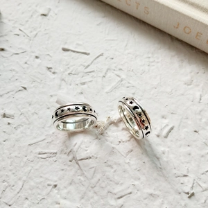 Close-up of rotatable S925 sterling silver star and moon ring on white background