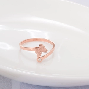 Détail d'une bague en or rose avec papillon givré et un petit cristal scintillant