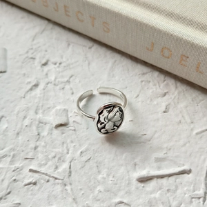 Close-up of S925 sterling silver ring featuring a vintage portrait relief on white texture
