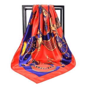 Detail of red and blue satin scarf featuring classic horse carriage and chain patterns