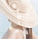 Detail showing natural straw hat texture with white pearl embellishments on the brim
