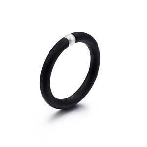 Minimalist matte black ring with a single white pearl accent on a clean white background