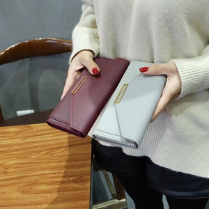 Detail of long leather wallets with envelope flap and gold metal bar decoration