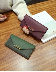 Detail of long envelope wallet with pebble leather and elegant gold metal buckle