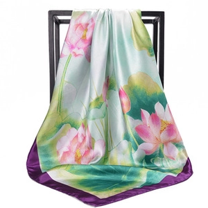 Detailed texture of square silk scarf with floral print and elegant purple border finish