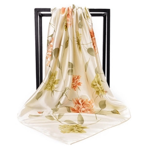 Detailed texture of satin square scarf with elegant chain and floral print pattern