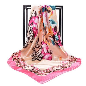 Close-up of pink floral satin square scarf with elegant silk texture on a black stand