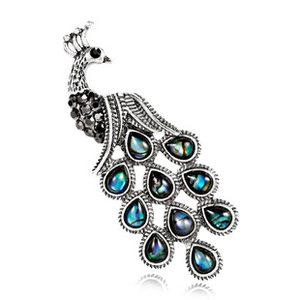 Detailed macro view of vintage peacock brooch featuring abalone shell and black rhinestones