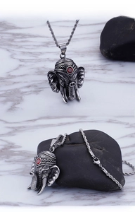 Macro detail of vintage elephant pendant with red gemstone and twisted steel chain