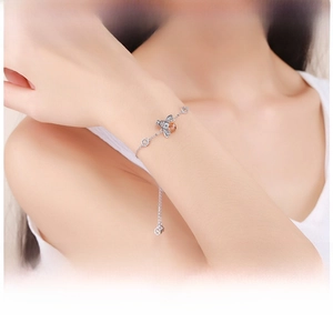Close-up of s925 silver bee bracelet with yellow pear-shaped zircon on a woman's wrist