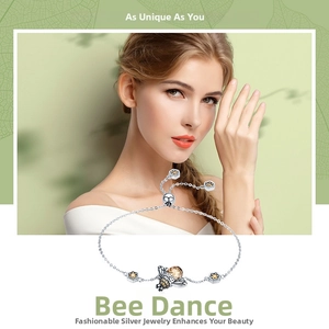 Detail of bee charm bracelet featuring brown gemstone inlay and yellow enamel accents