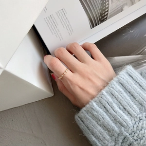 Vista dettagliata di un elegante anello sottile in oro con zirconi lucidi indossato da una modella