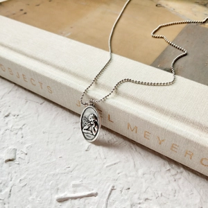 Detailed view of an oval S925 sterling silver guardian angel relief pendant on a ball chain