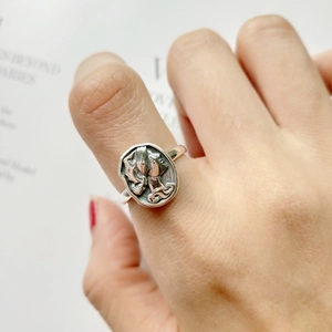 Close-up of vintage sterling silver ring with irregular round embossed relief on finger