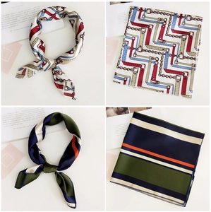 Detail of silk-like square scarves featuring vintage chain prints and geometric stripes