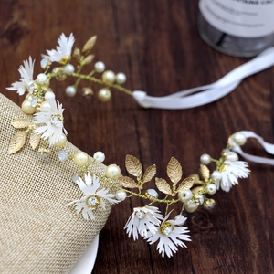 Detail of bridal hair vine with white daisy flowers, gold leaves, pearls and crystals
