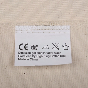 Macro view of a canvas gift bag detail with wash instructions and CE certification tag