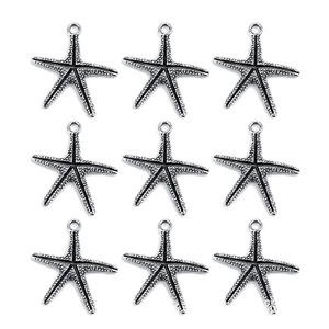 Macro detail of nine silver starfish alloy pendants with textured finish on white background