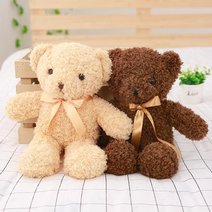 Soft cream and dark brown teddy bear plush toys with satin bows in a cozy home setting
