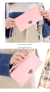 Detail of pink PU leather wristlet with embroidered cherry pattern and metal zipper