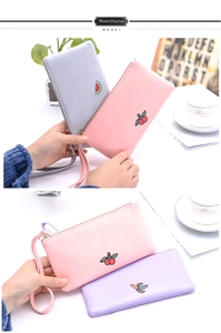 Detail of Korean style fruit embroidery on synthetic leather wristlet with zipper