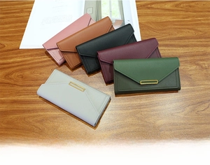 Flat lay of envelope-style long wallets in six colors with gold metal buckles