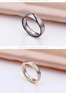 Detail showing two-tone titanium steel couple rings with brushed finish and single diamond
