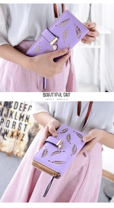 Detailed close-up of light purple long wallet with hollow leaf design and metal pendant