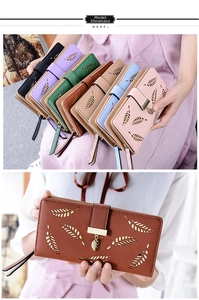 Close-up of laser-cut leaf pattern and tassel pendant on a long faux leather wallet
