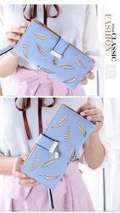 Close-up of light blue long wallet featuring hollow leaf pattern and gold charm