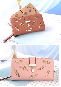 Detail of leaf cutout pattern and metal pendant on long leather bifold wallets