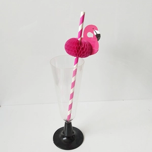 Close-up of pink striped paper straw with a honeycomb flamingo decoration in a glass