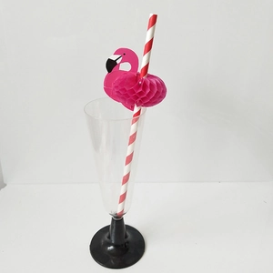Pink flamingo honeycomb decoration on red and white striped paper straw in a clear glass