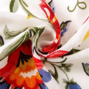Macro detail of summer floral scarf fabric showing weave texture and colorful print