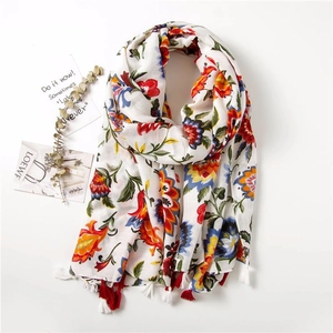 Detailed view of colorful floral prints and red fringe tassels on lightweight summer shawl