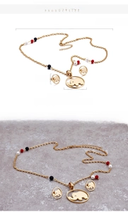 Détails des dimensions de la parure éléphant plaquée or 18 carats et vue sur pierre texturée