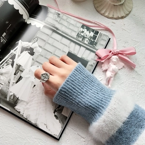 Detail of vintage 925 sterling silver cross ring worn on finger with soft knit sweater