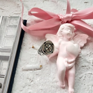 Detail shot of vintage 925 sterling silver cross seal ring on aesthetic background
