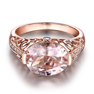 Detailed view of rose gold ring with pink oval stone and intricate hollowed band