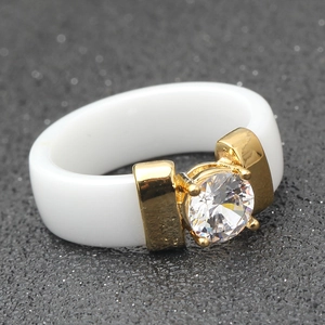 Macro shot of 6mm white ceramic ring with gold metal base and sparkling cubic zirconia