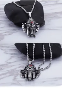 Close-up of vintage elephant pendant with red gemstone and silver rope chain detail