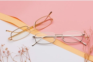 Primer plano de monturas de gafas de sol cuadradas en metal dorado y plateado con fondo de color